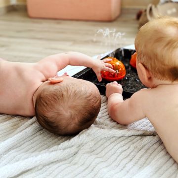 Babys beim Spielen mit Wasserfontäne